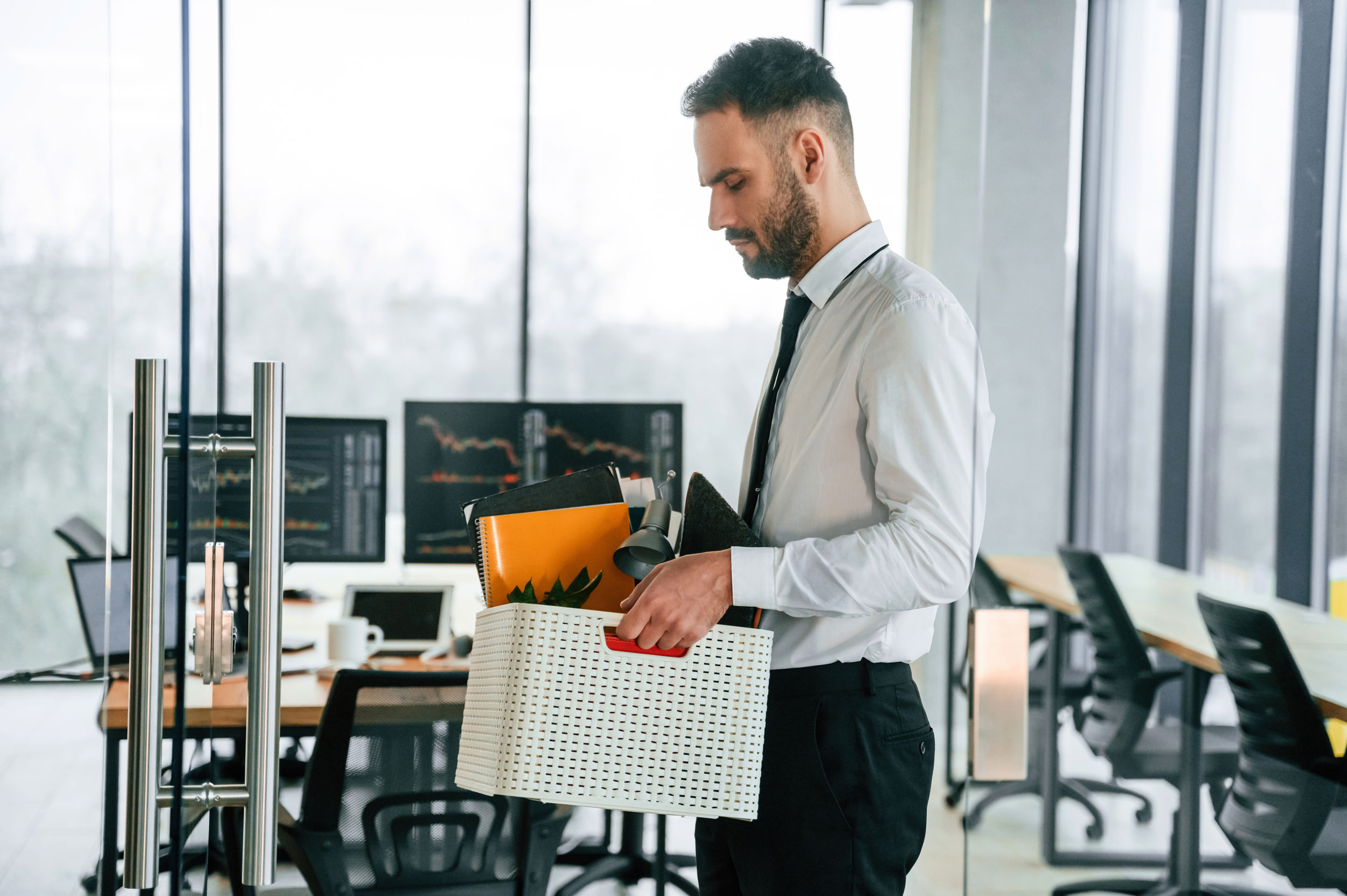 Man carrying box of belongings out of the office