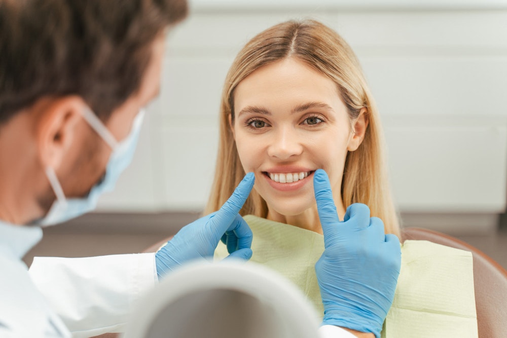 Patient looking at smile with dentist's help