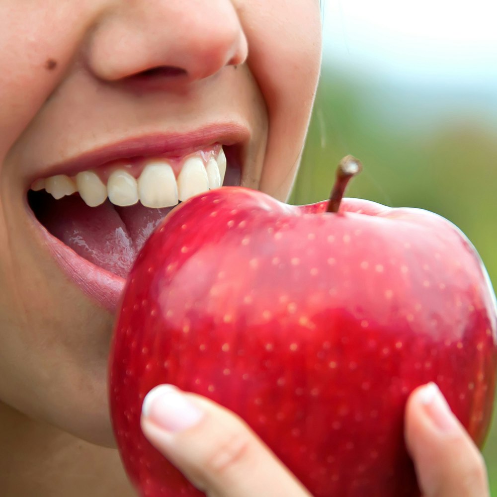 a person biting into an apple