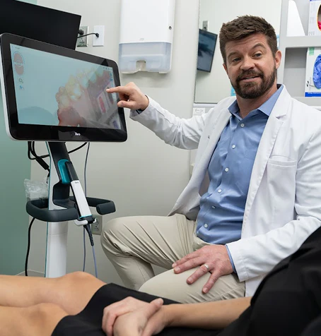 Dr. Burton Gooch showcasing iTero scanner to patient