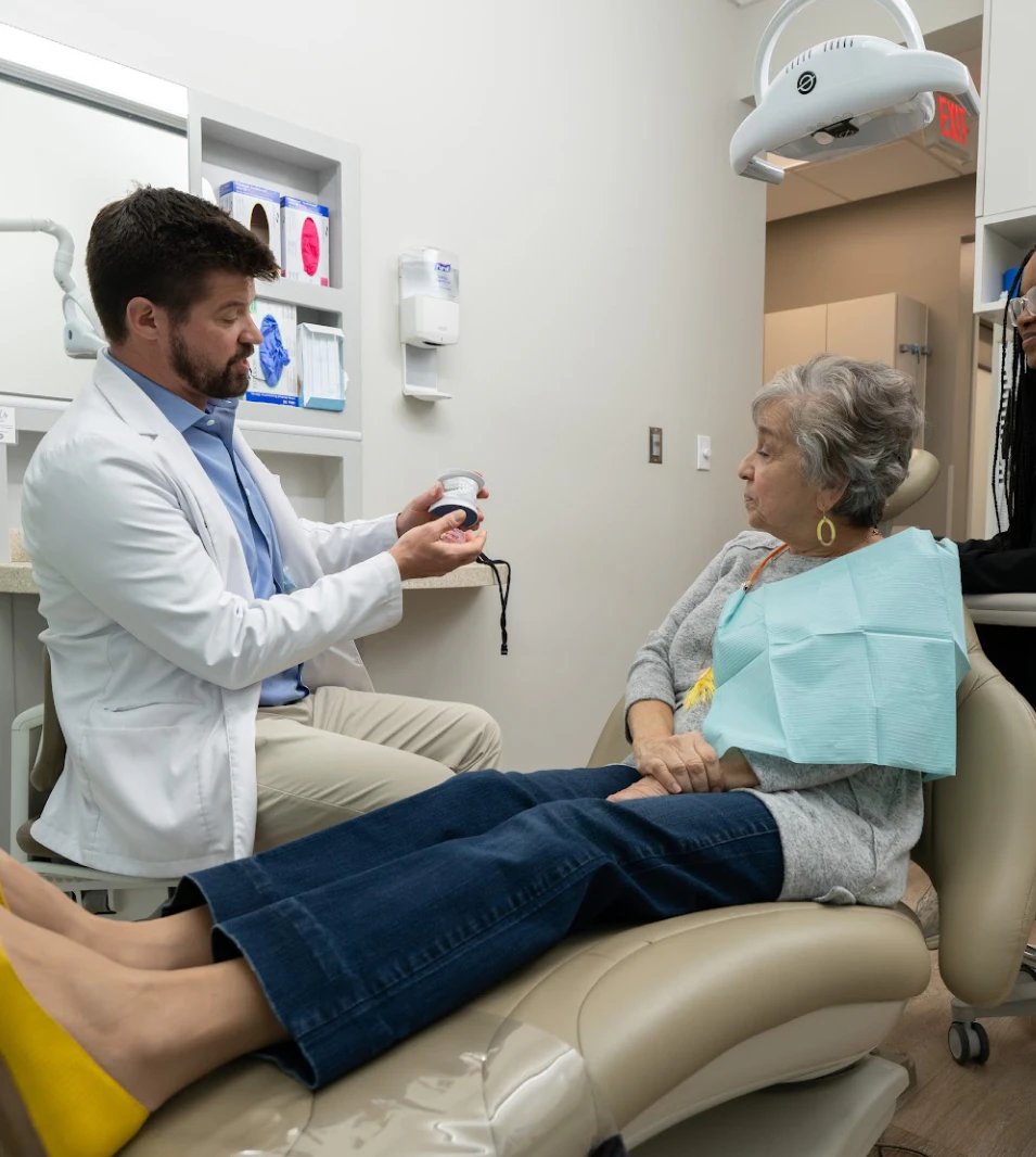 Dr. Burton Gooch showing patient a tooth model