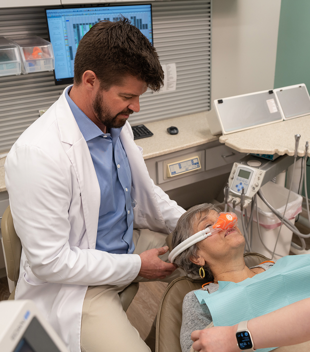Dr. Gooch placing nitrous oxide hose on patient