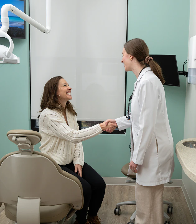 Doctor Mallory Lanford shaking hands with a patient while smiling