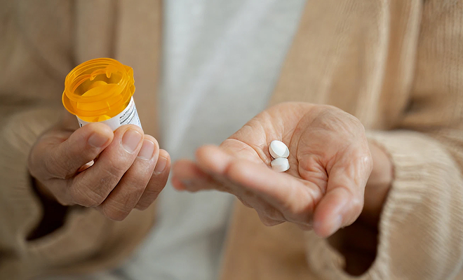 Close-up of hands holding prescription pills
