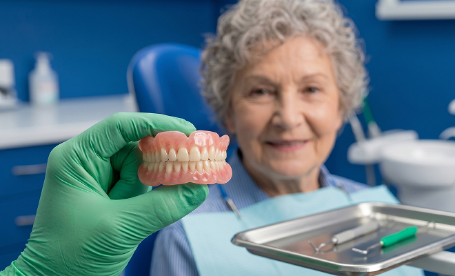 Senior woman being shown dentures