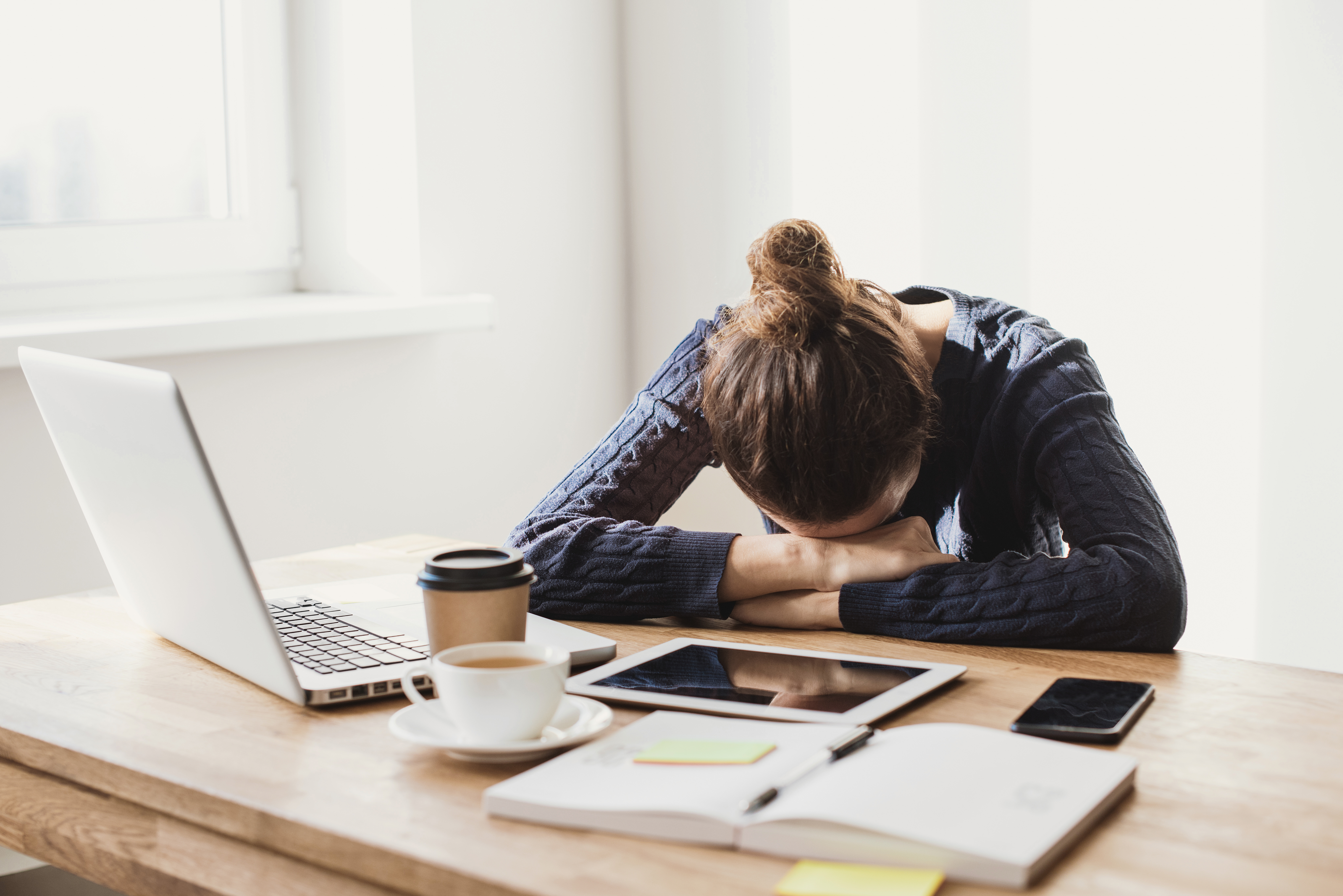 young woman falling asleep at her desk