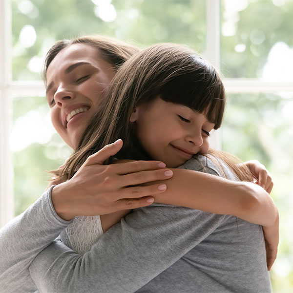 Mother hugging daughter