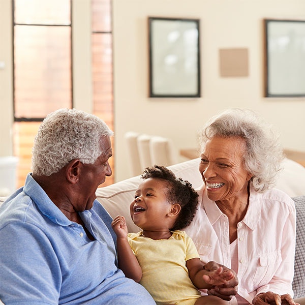 Grandparents sitting on couch with grandchild