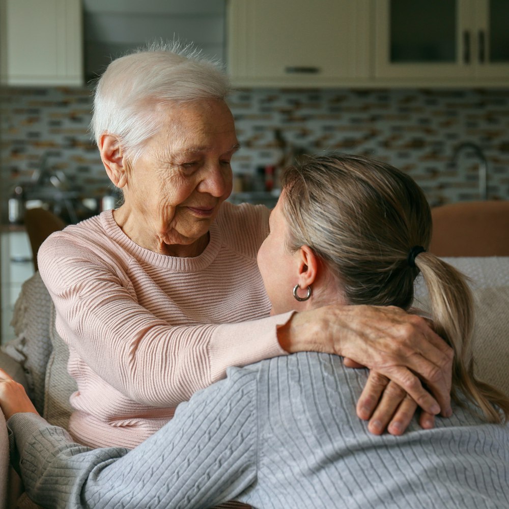 Daughter hugging elderly mother