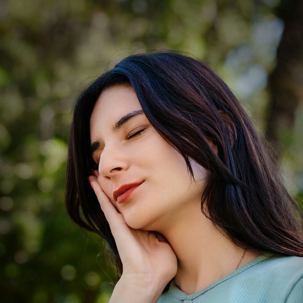 Woman with gum disease holding jaw in pain