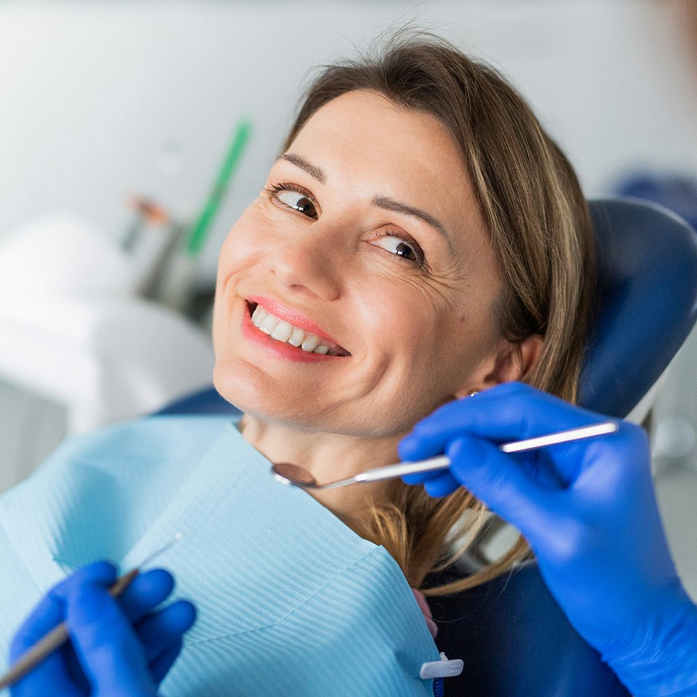 Smiling woman at dentist before an oral cancer screening