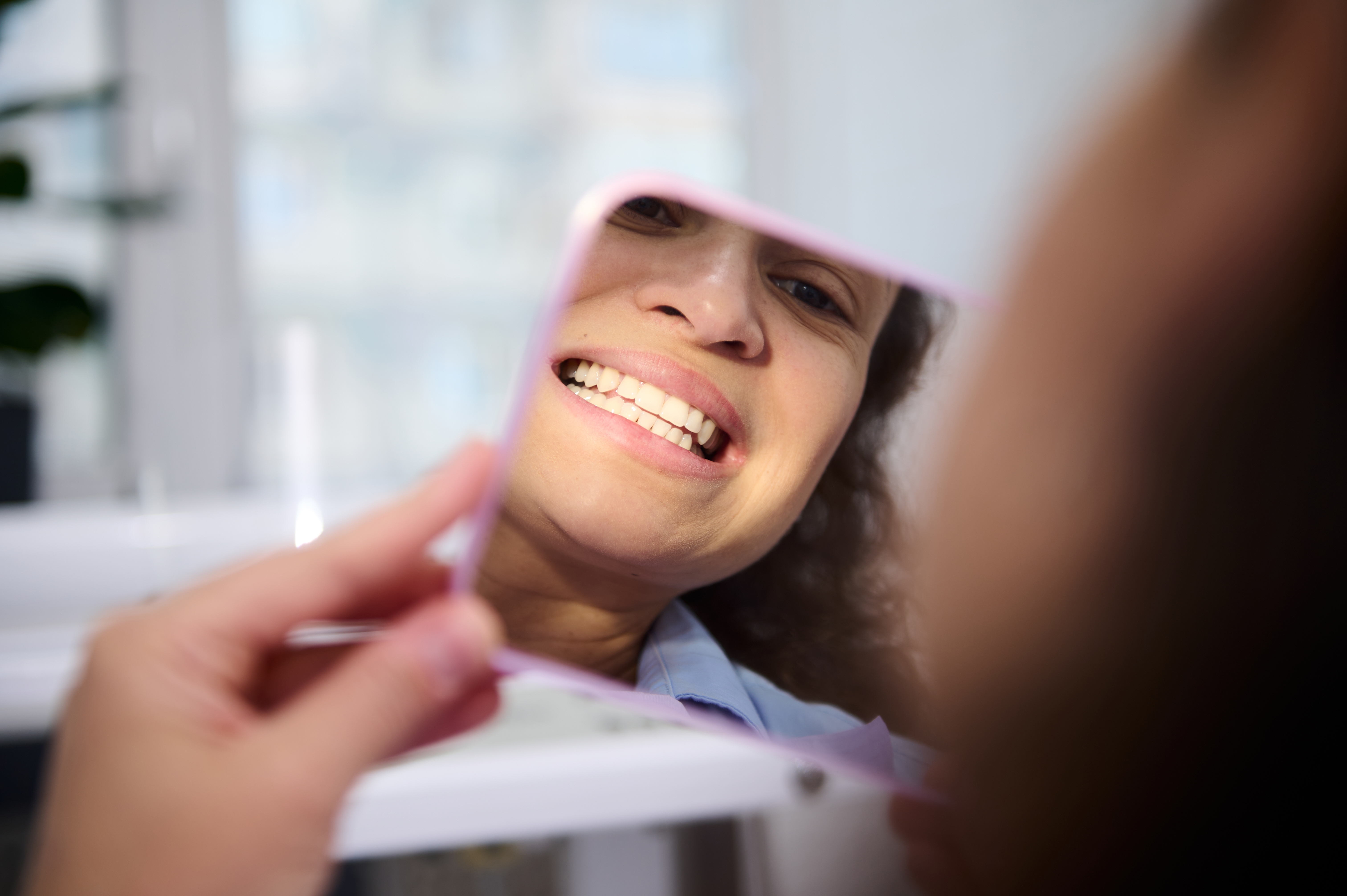 Smiling mature woman looking at herself in the mirror
