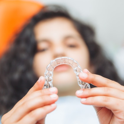 patient holding out invisalign aligner