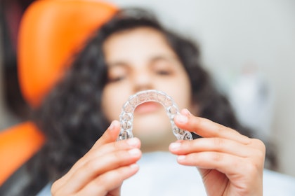 patient holding out invisalign aligner