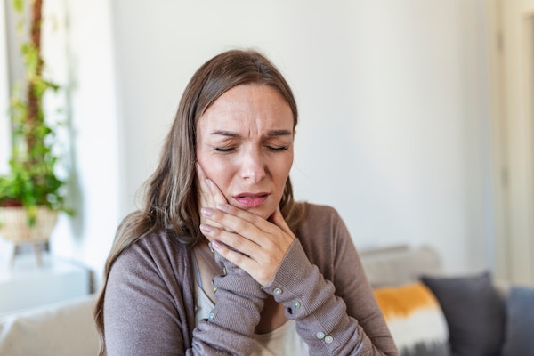 Woman clutching jaw in pain