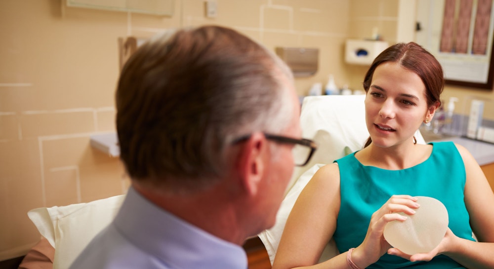 Woman looking at implants at a breast augmentation consultation