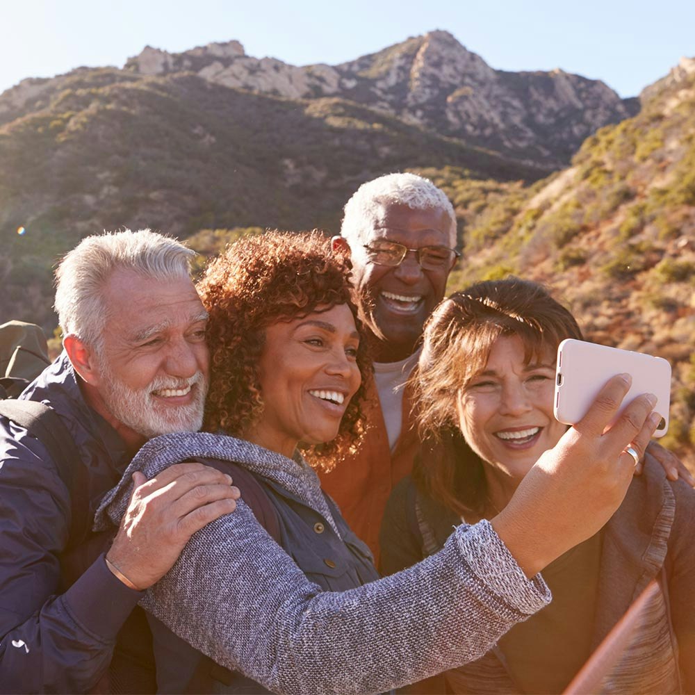 Two older couples smiling for selfie