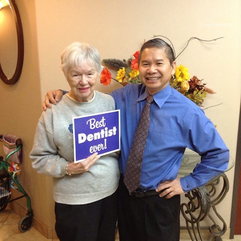 Patient holding a sign that says Best Dentist Ever with Dr. Phan