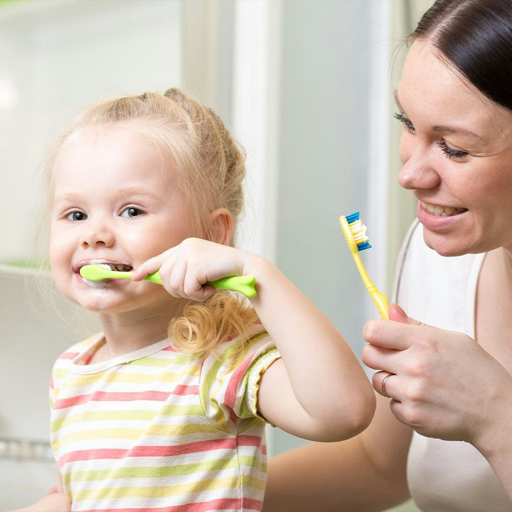 Smiling child brushing teeth