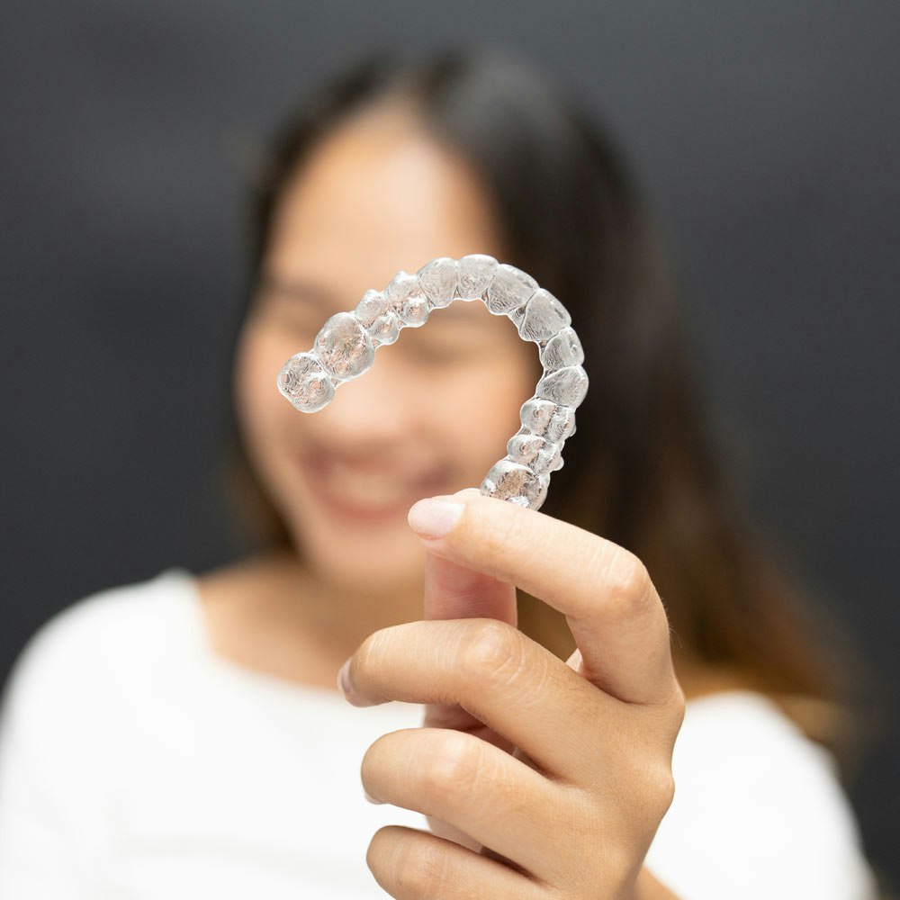 Woman holding Clear Aligners up close