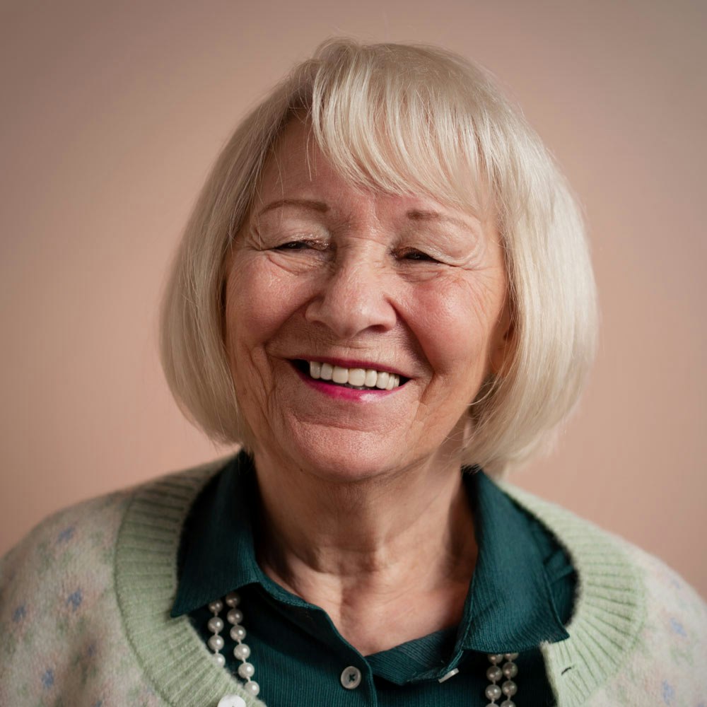 Smiling mature woman after dental crowns treatment
