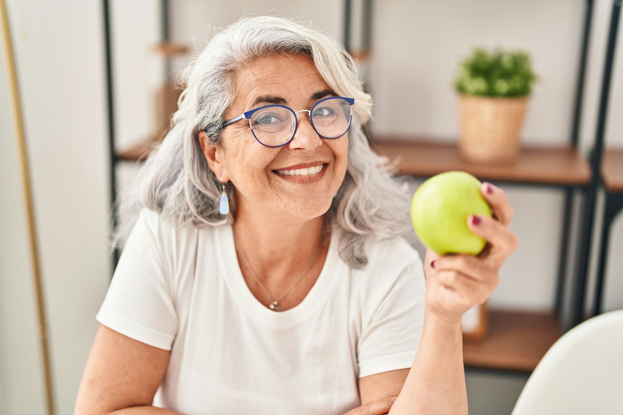 Woman smiling while holding an apple