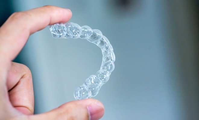 Hand holding out Invisalign