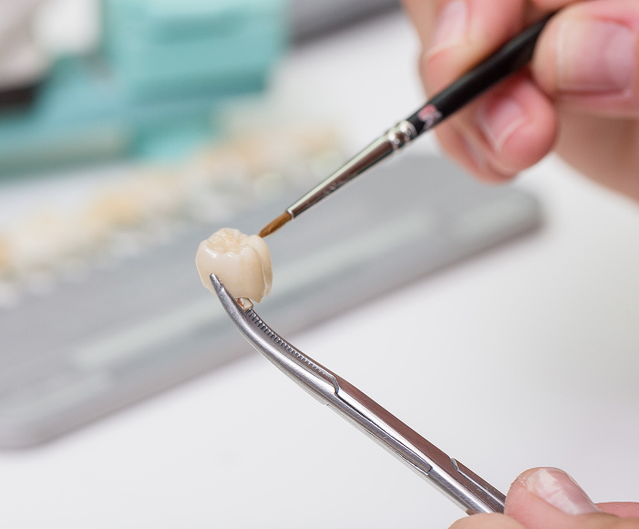 lab tech painting a dental crown