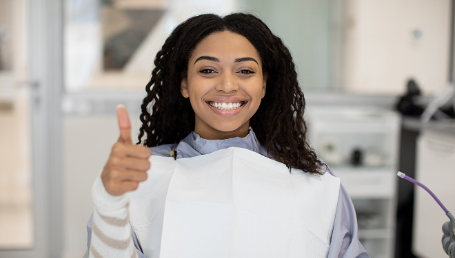 girl at the dentist giving a thumbs up