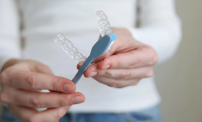 Close up of someone brushing their aligners
