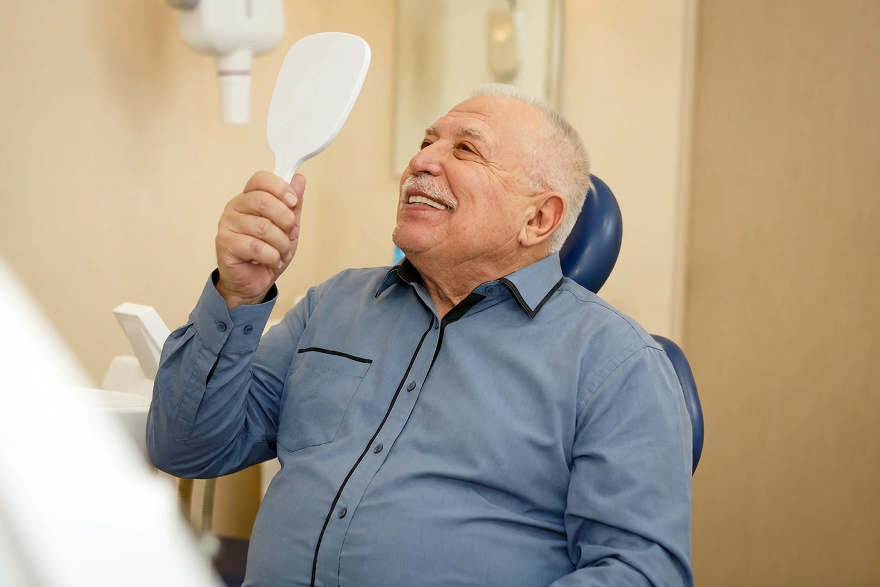 Elderly man smiling in a dental mirror
