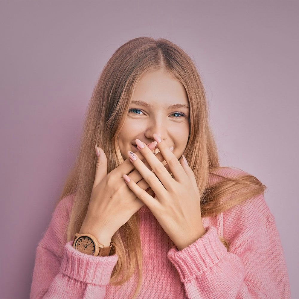 Woman hiding mouth behind hands