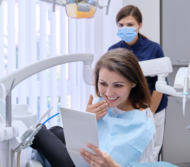 Woman happily looking at her smile after treatment