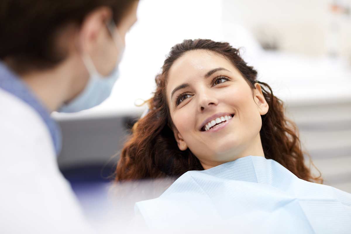 Woman reclining comfortably in dental chair during exam