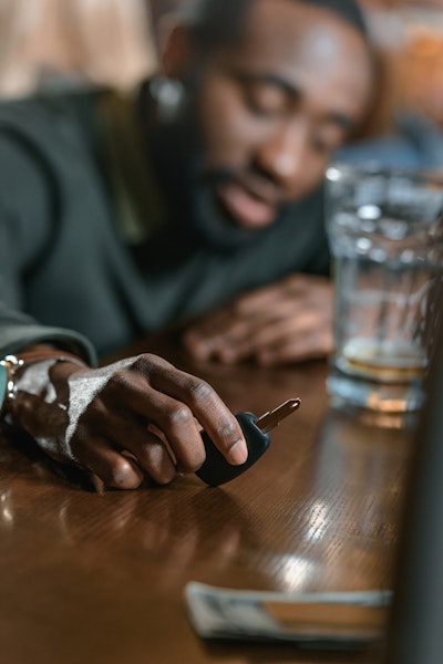 Drunk man reaching for car keys in a bar