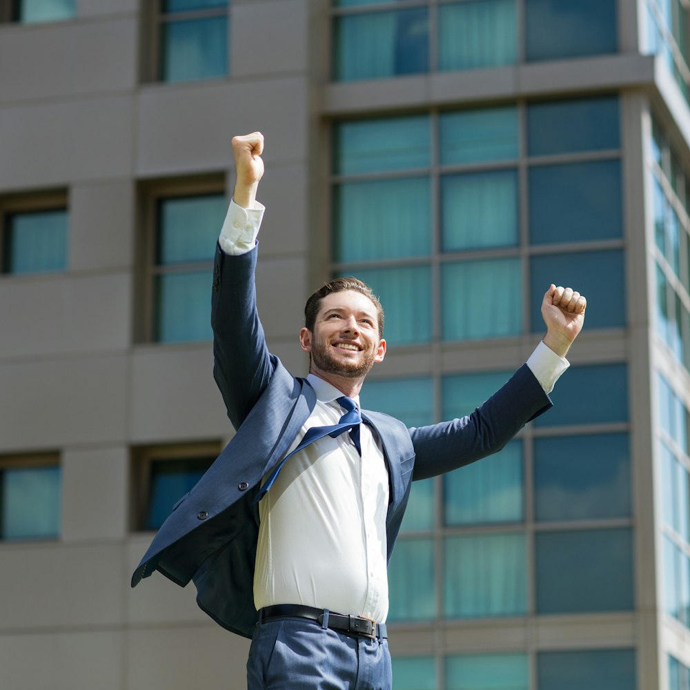 Man in suit throwing his hands up in air in celebration