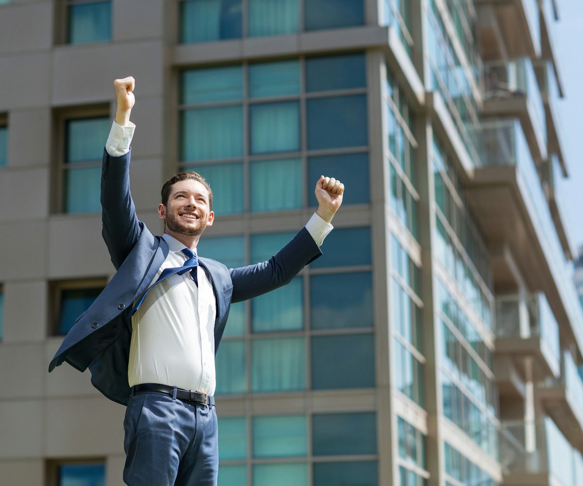 man raising arms in victory