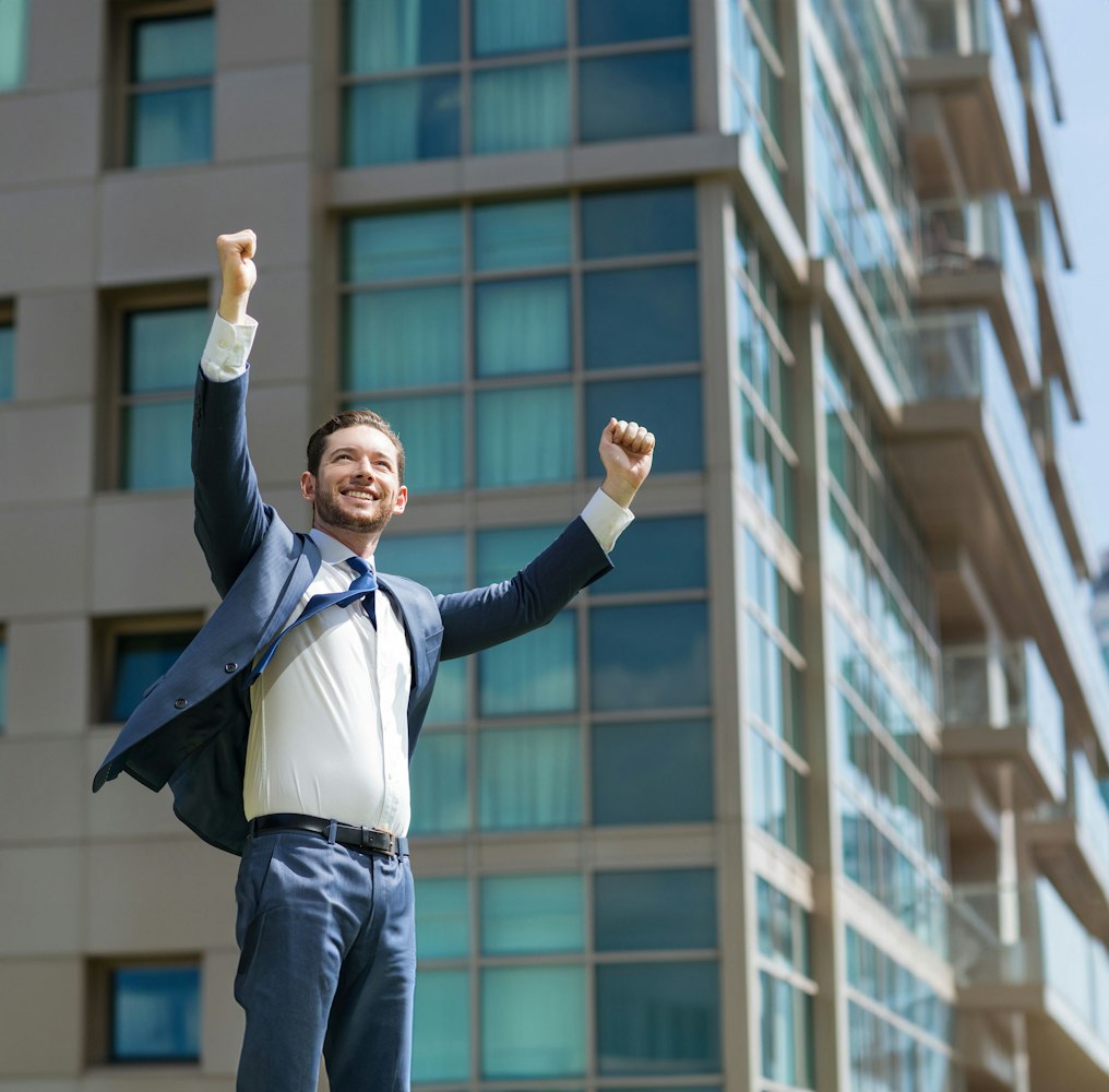 man raising arms in victory