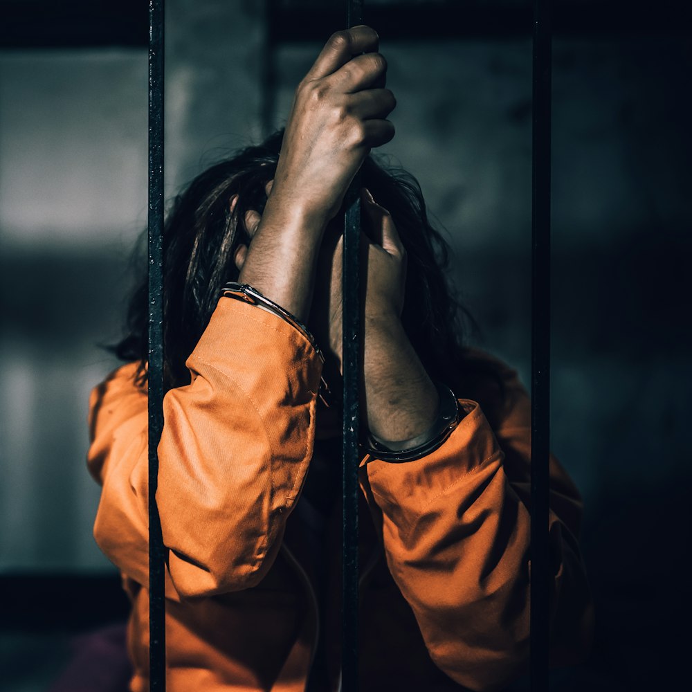 Woman in orange behind bars