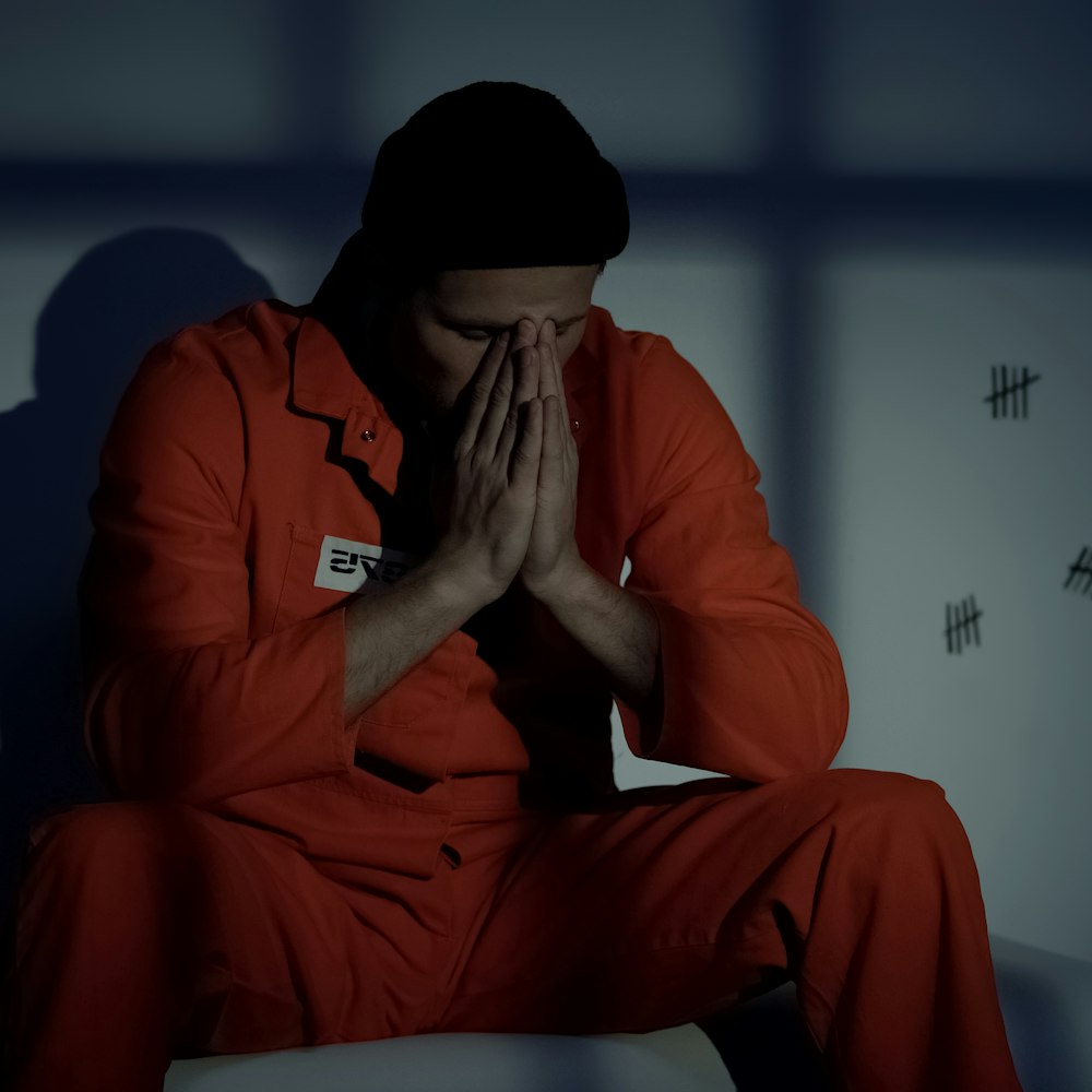 Man in jail with head in hands