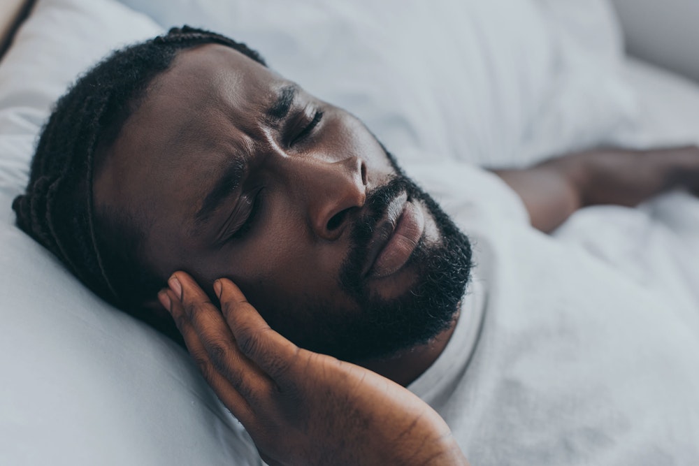Man with headache in bed