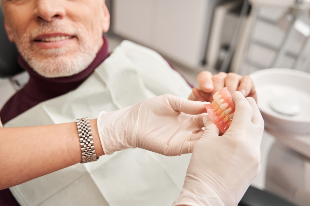 Dentist holding dentures