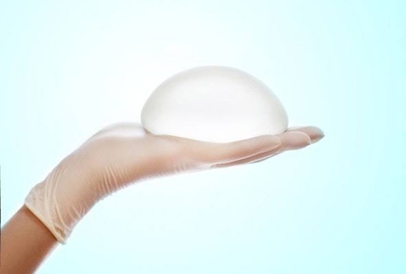 Breast implant in gloved hands