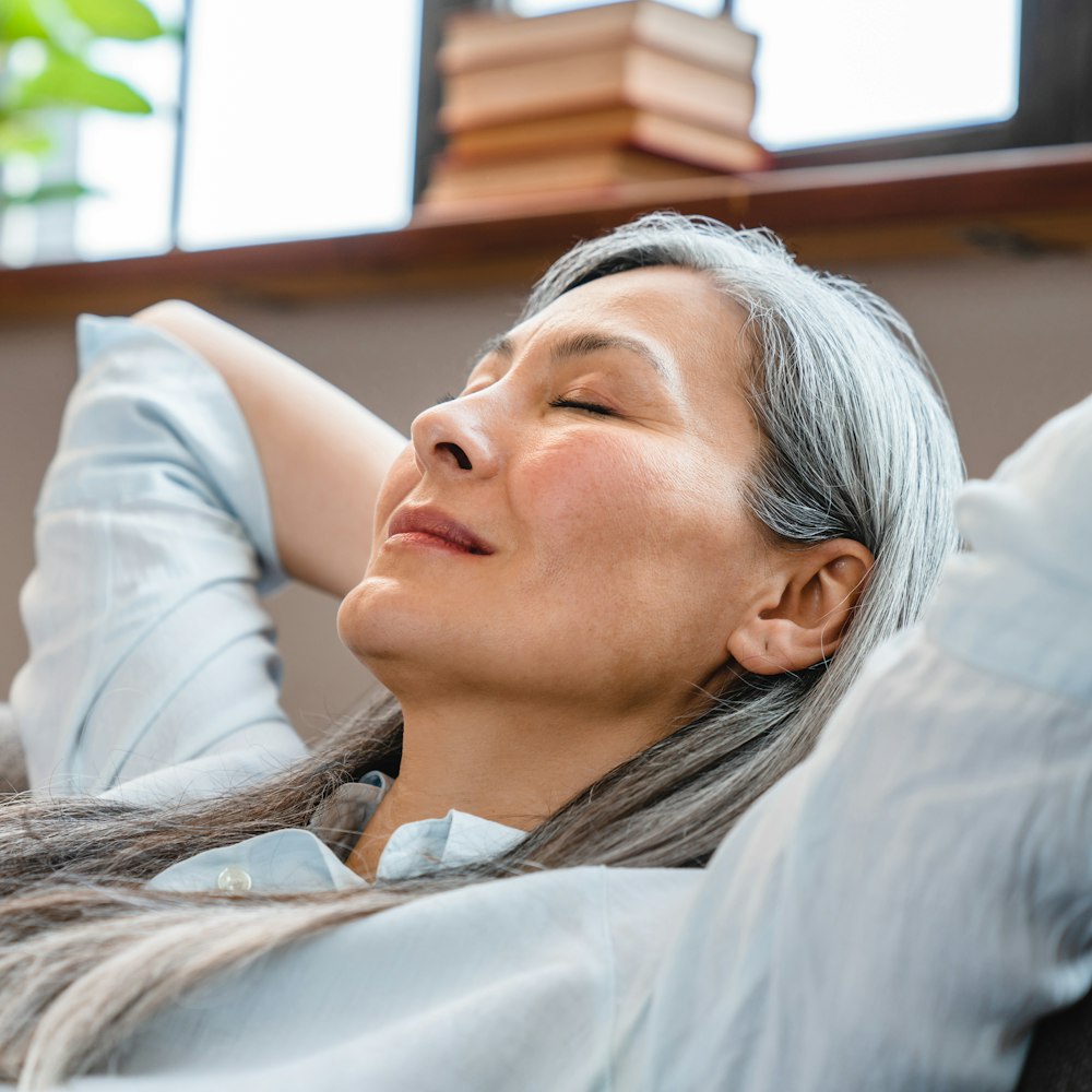 Woman cradling head in arms, stretching back and relaxing
