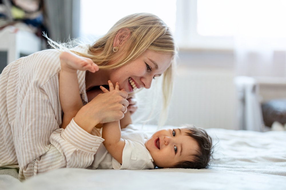 mom laying with baby in bed