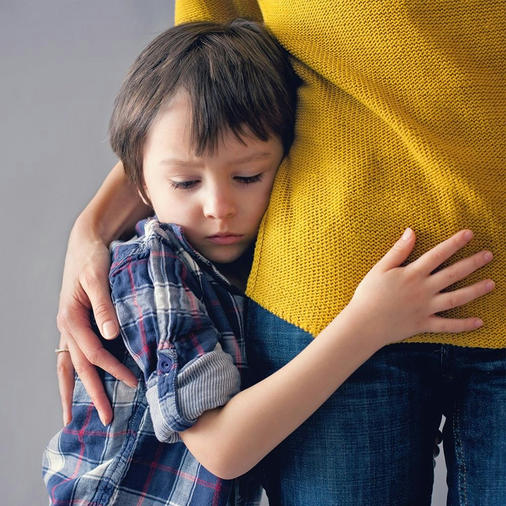 shy child hugging mom