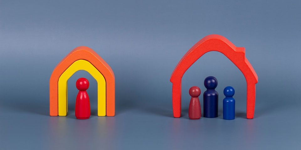 Wooden blocks and toys representing a family in two different homes