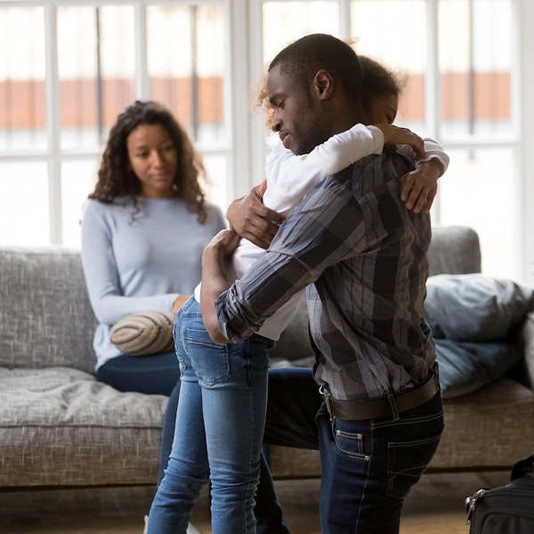 Daughter hugging father while mother sits in the background