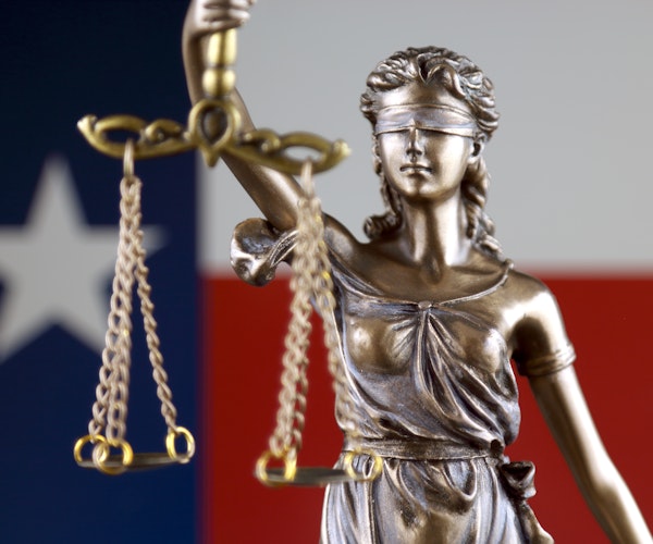 Lady Liberty holding justice scales with Texas flag in the background