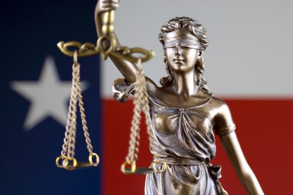 Lady Liberty holding justice scales with Texas flag in the background